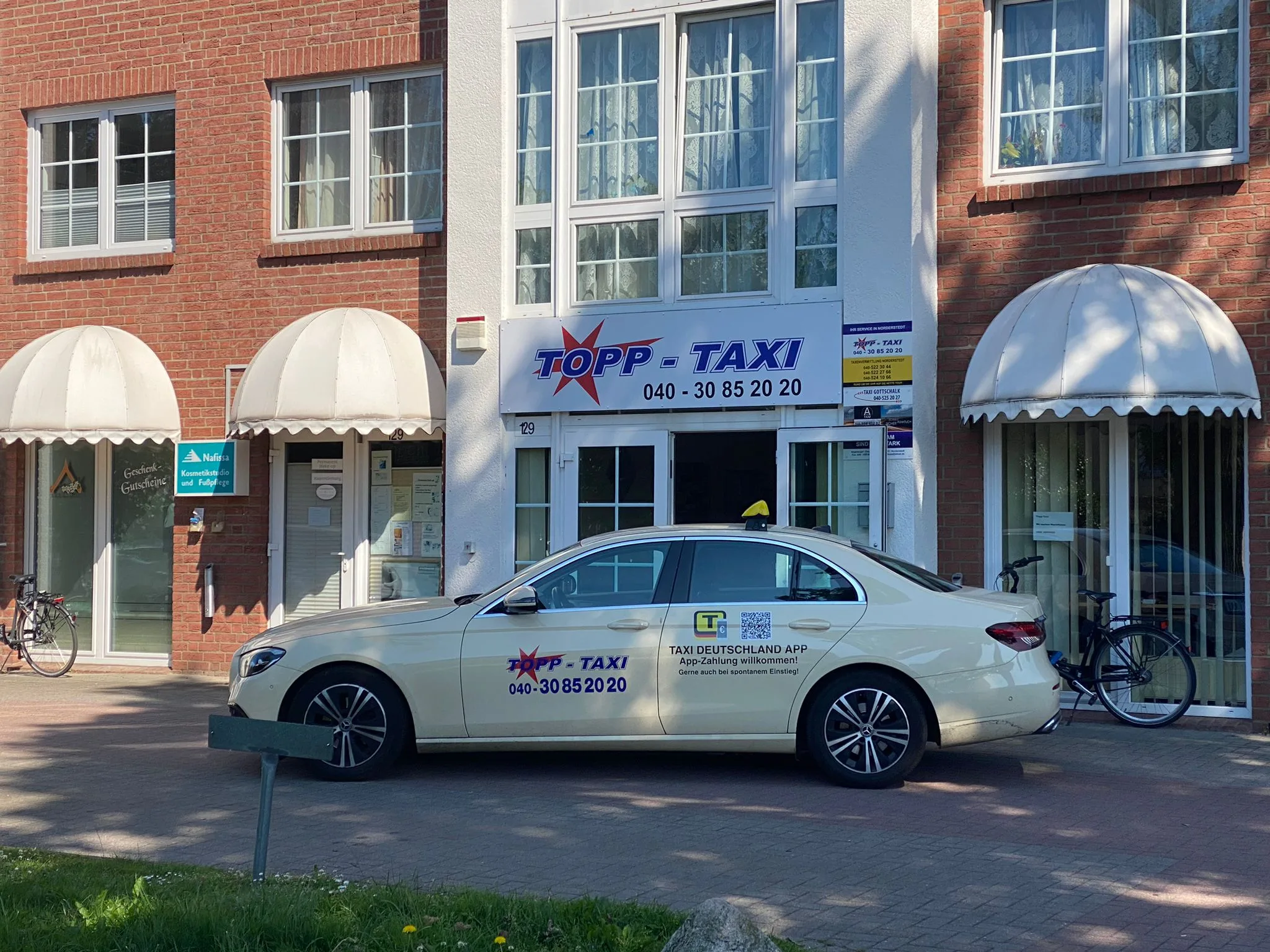 Topp Taxi Zentrale Norderstedt mit Taxi vor dem Eingang